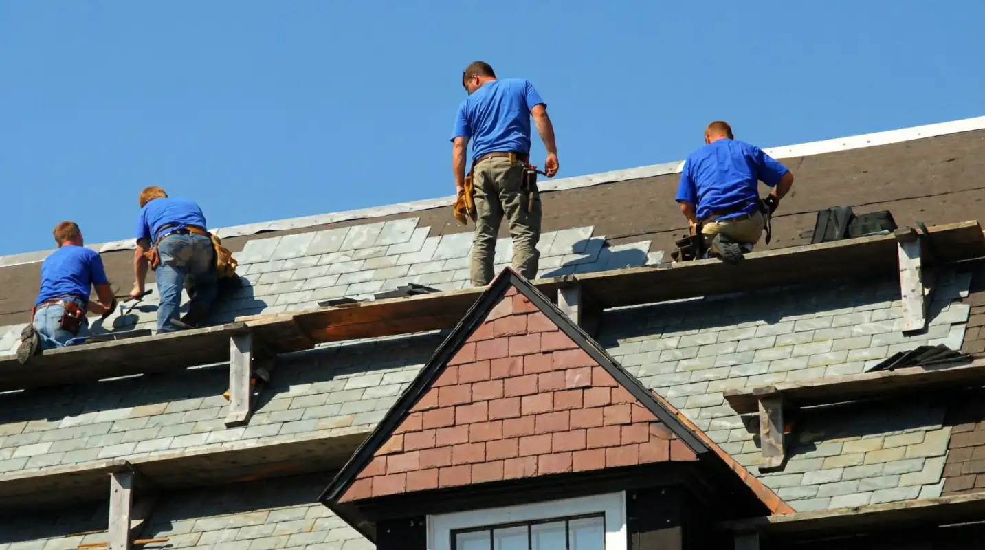 Roof replacement in progress with a team of professional contractors installing new shingles on a residential home in Grand Rapids, Mi