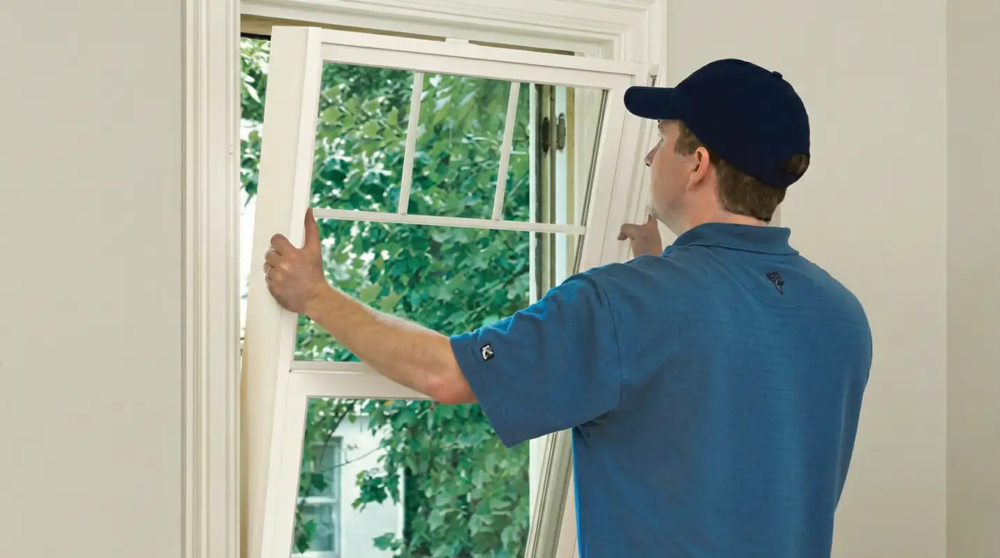 Professional contractors performing a residential window insulation and replacement service in Grand Rapids, Mi